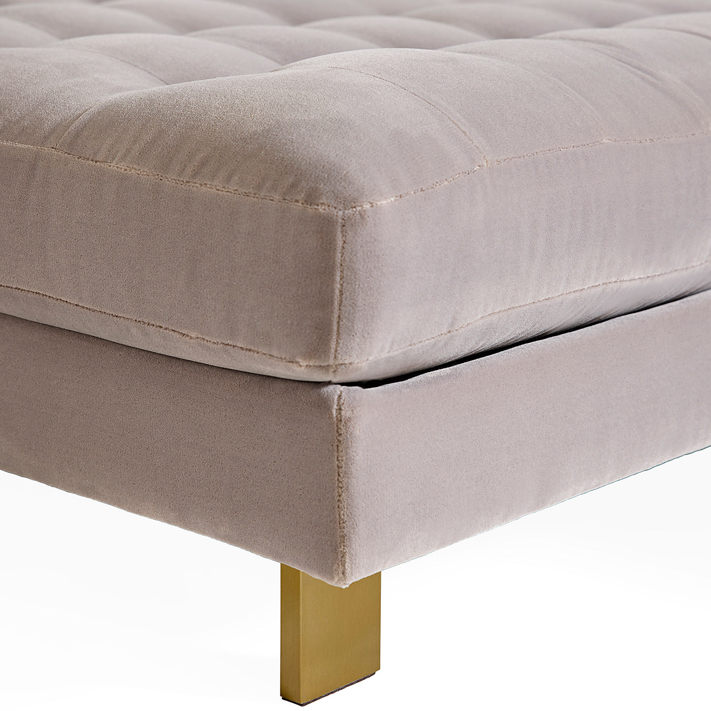 Gray upholstered ottoman with a gold leg on a white background