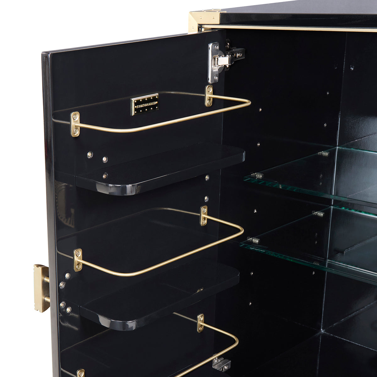Close-up of the open interior of a black display cabinet or cabinet door, showing three black shelves with gold metal wire racks and glass shelves inside.