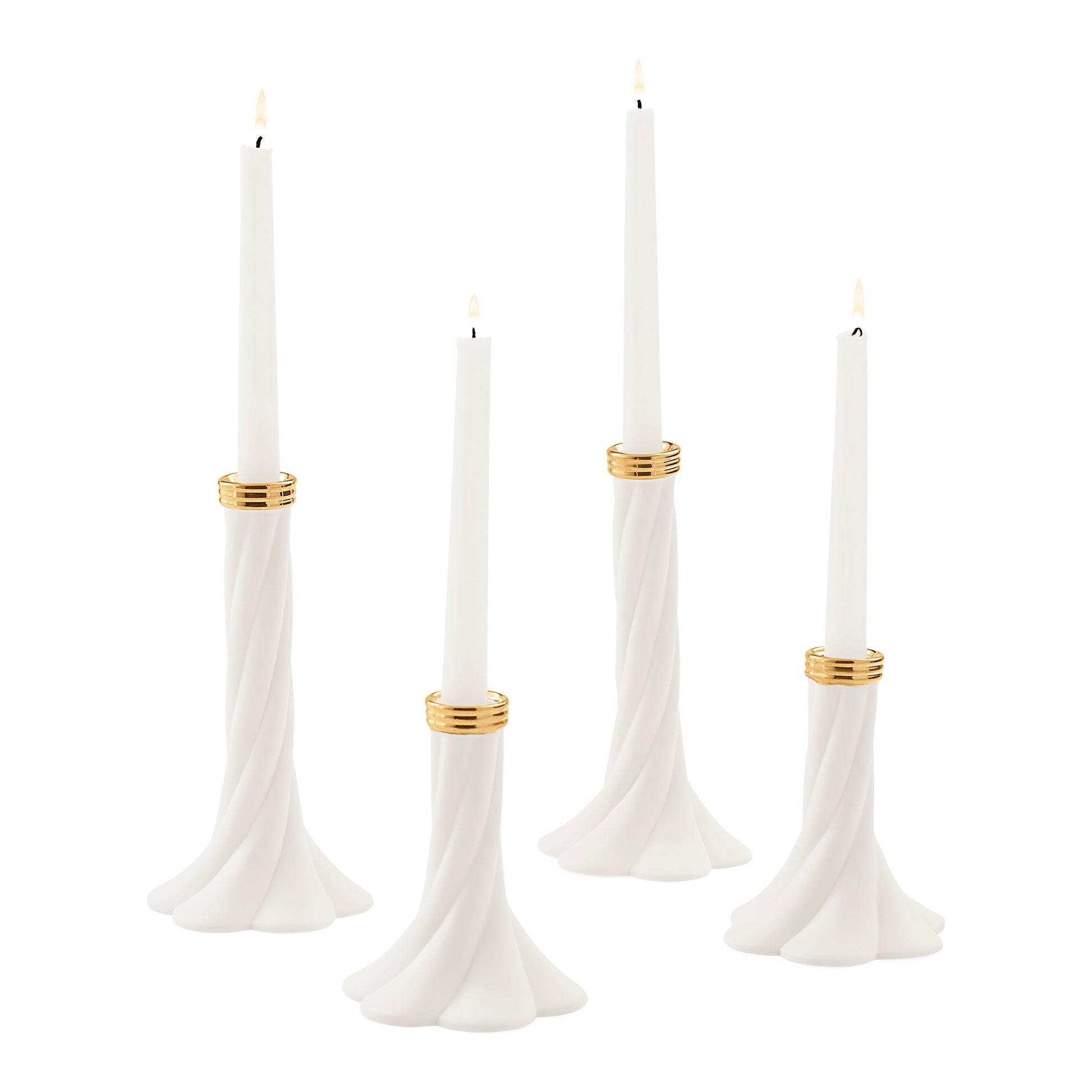 Four white taper candles in sculpted white holders with gold bands, shown on a plain white background.