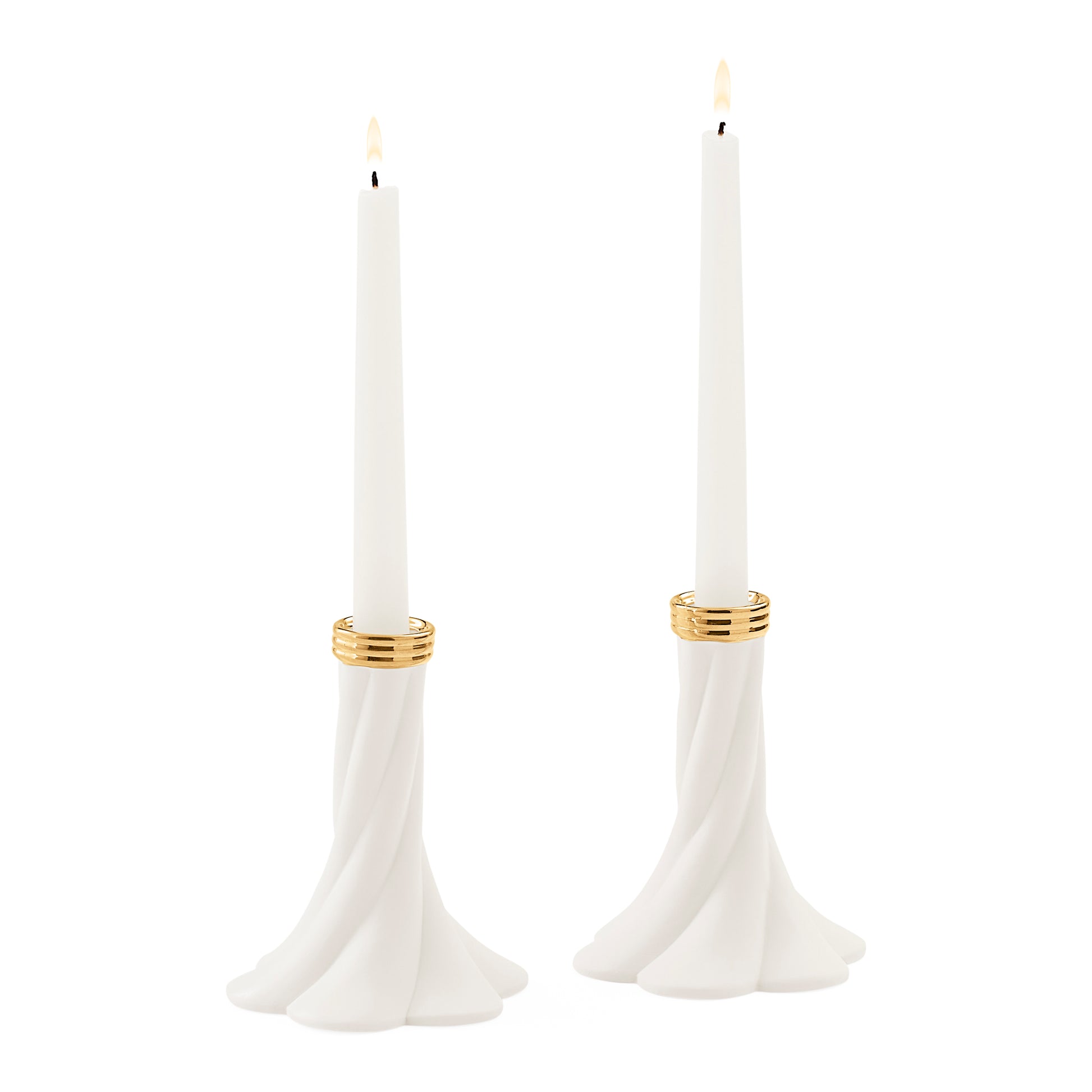 Two white taper candles in sculptural flared holders with gold bands, shown on a plain white background.