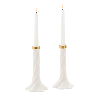 A pair of white taper candle holders with a twisted base and gold metallic bands, each holding a white taper candle with a lit flame, set against a solid white background.