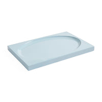 A light blue rectangular shower tray with an integrated oval drain, shown at an angle on a solid white background.