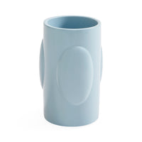A light blue ceramic mug with a unique sculptural design featuring a large oval embossed on the front and side handles, shown on a plain white background.