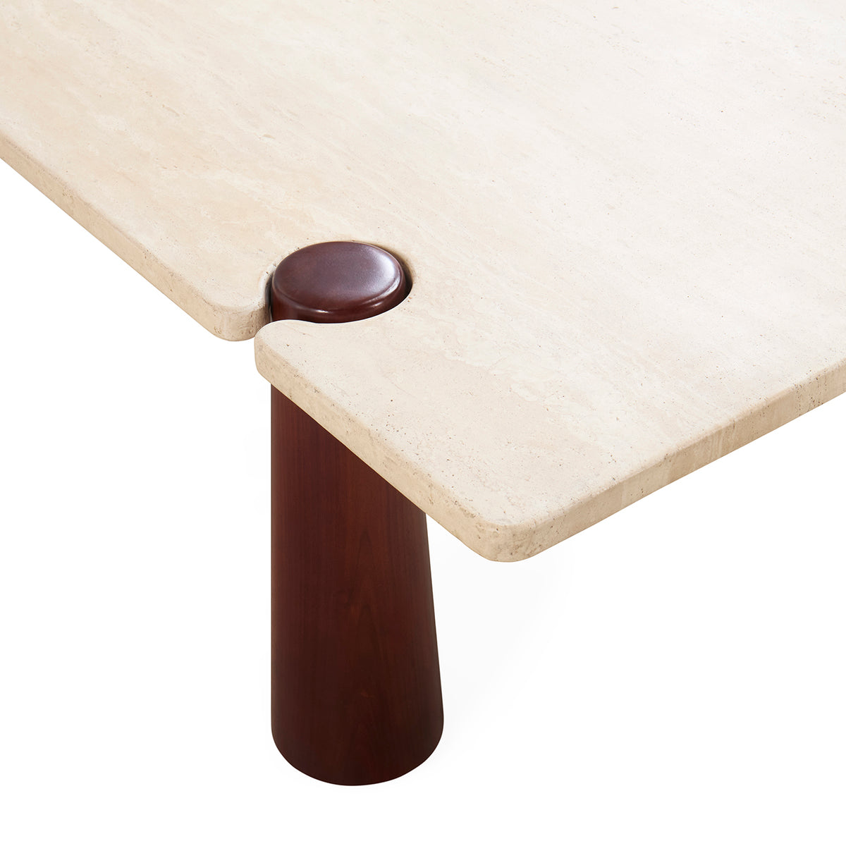 Close-up of a modern table corner showing a light beige stone or travertine tabletop with a dark reddish-brown circular joint and matching cylindrical leg on a white background.