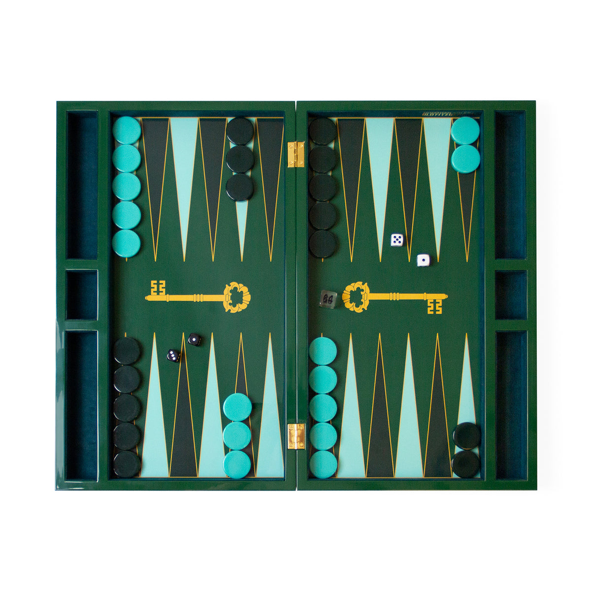 A top-down view of an open folding backgammon board set on a plain white background. The board is dark green with alternating light teal and black triangles, decorated with a large gold key motif in the center.