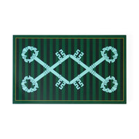 A rectangular green mat or rug featuring a dark green and forest green vertical striped pattern, bordered by a thin gold line. In the center is a large mint-green decorative key motif that crosses over itself, with four matching key handles arranged around it.
