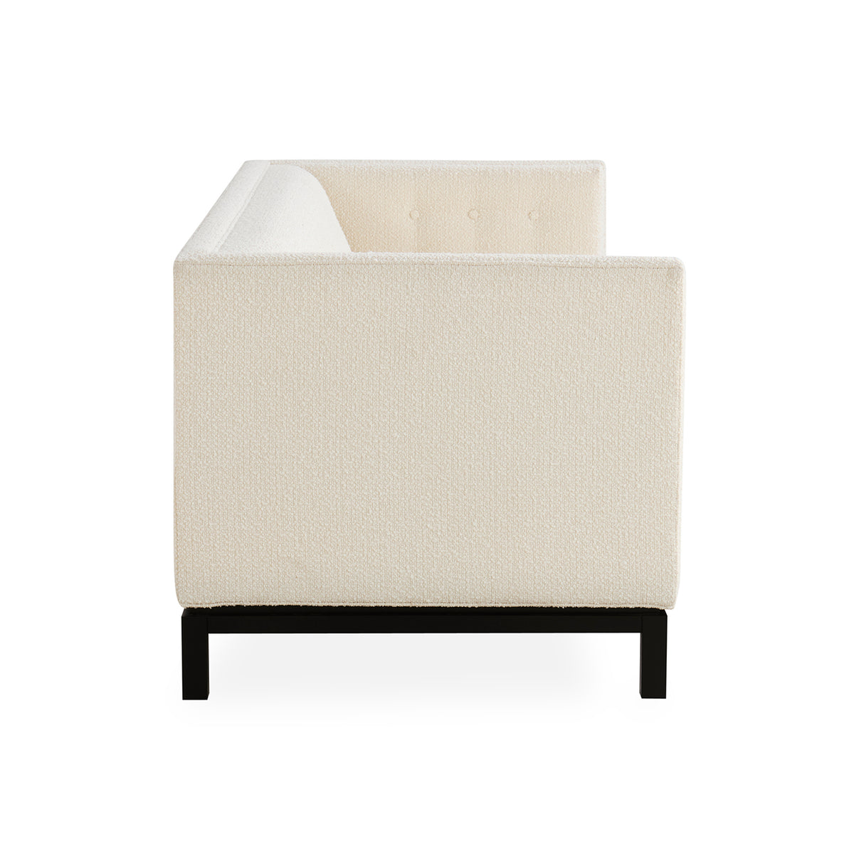 A modern low-profile armchair with textured cream upholstery and a black metal frame, shown from a rear three-quarter angle on a white background.