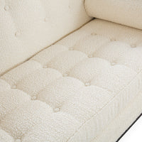 Close-up of a cream bouclé upholstered sofa seat with tufted button details and a matching back cushion.