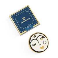 Decorative plate with artistic design and Jonathan Adler packaging on a white background