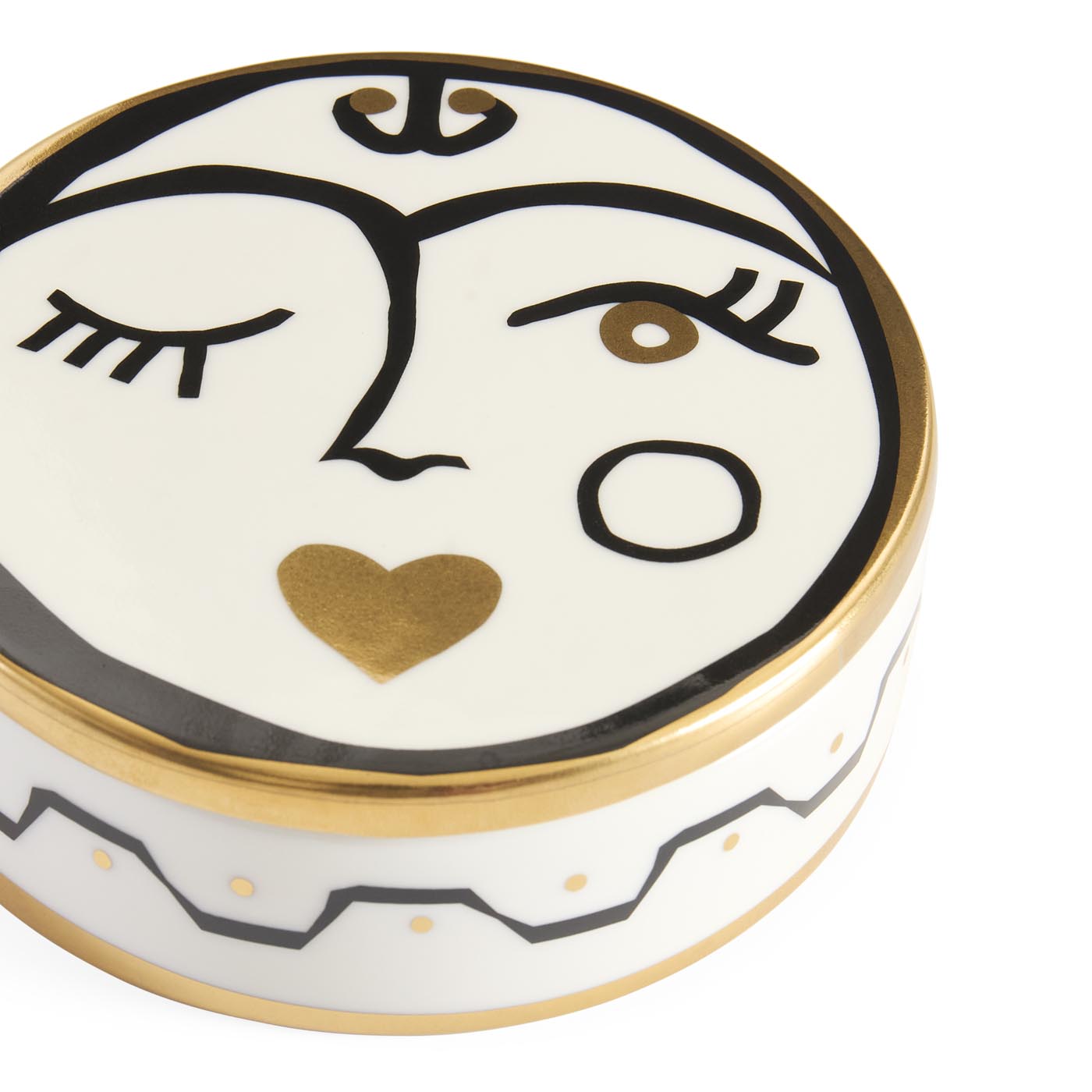 Decorative ceramic face with gold accents on a white background