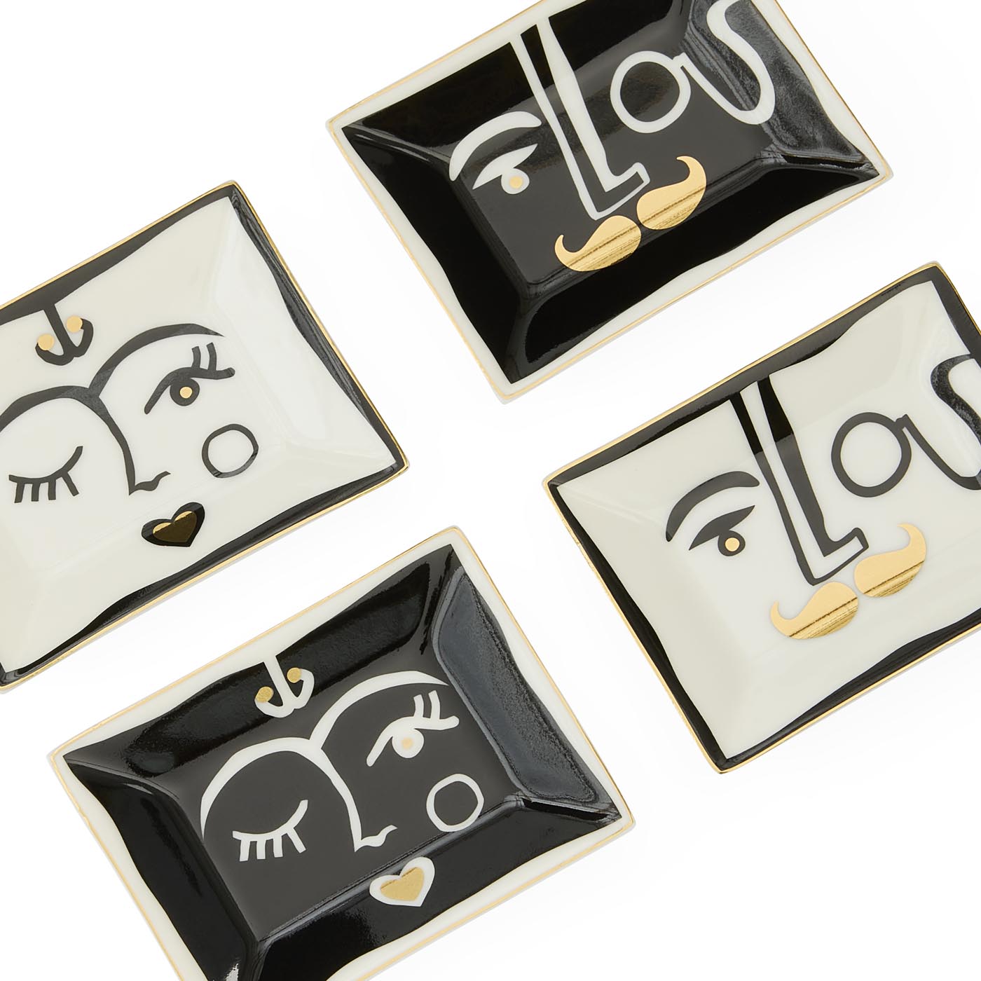 Four decorative trinket dishes with face designs on a white background