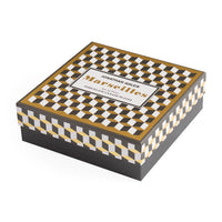 Decorative box with checkered pattern and 'Jonathan Adler Marseilles' branding on a white background
