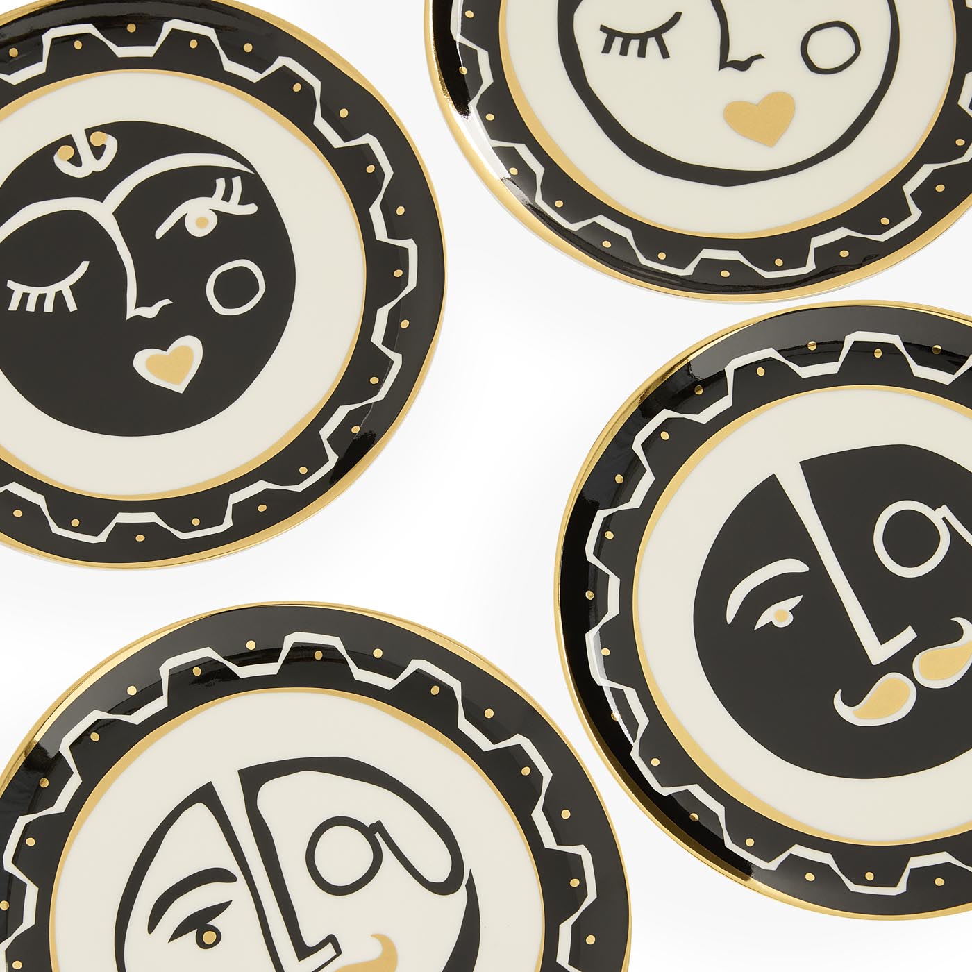 Set of decorative plates with abstract face designs on a white background