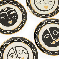 Set of decorative plates with abstract face designs on a white background