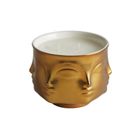 porcelain candle with gold exterior; two wick; face shaped ; unlit 