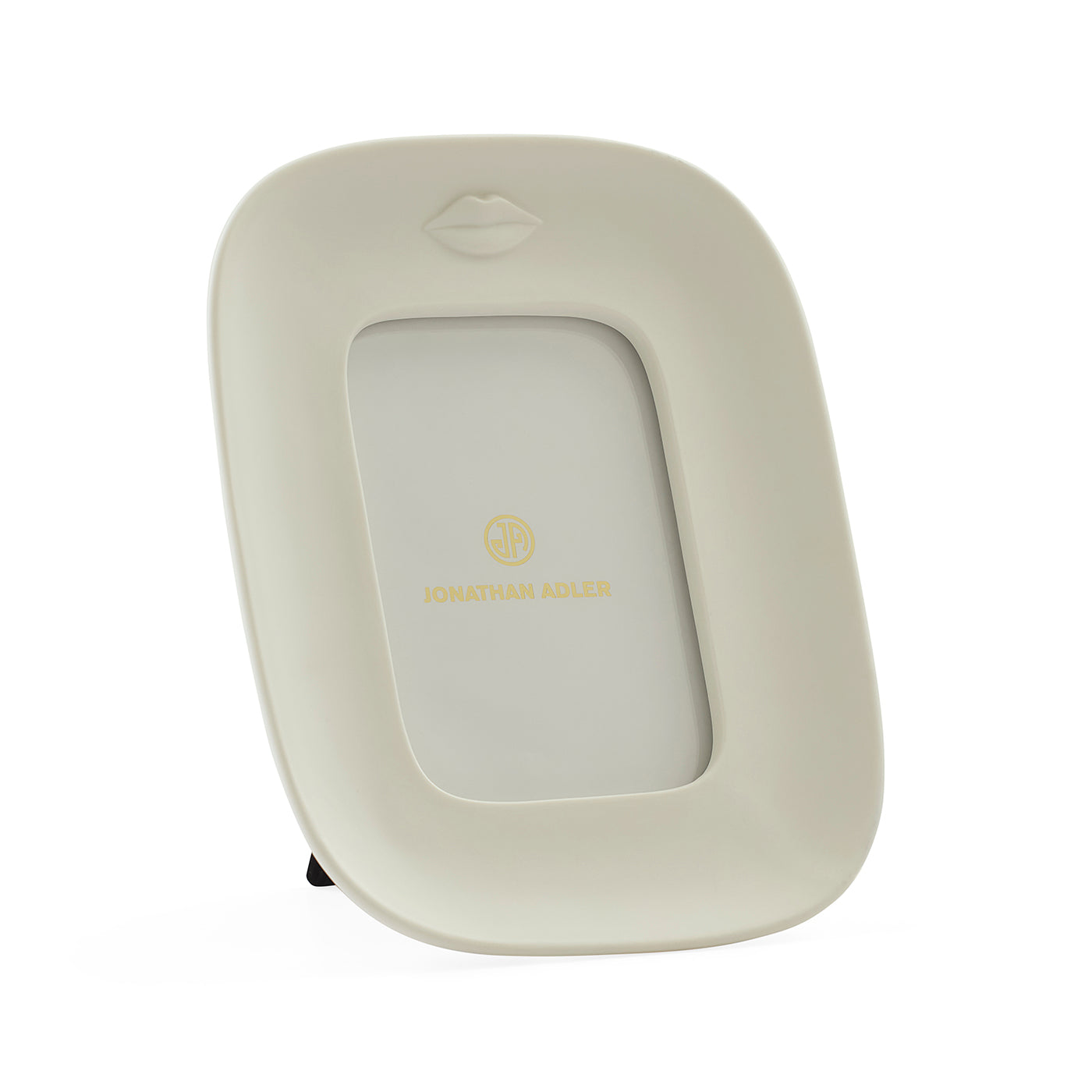 A cream-colored picture frame with a small embossed lips design at the top and gold 'JONATHAN ADLER' branding in the center, shown on a clean white background.