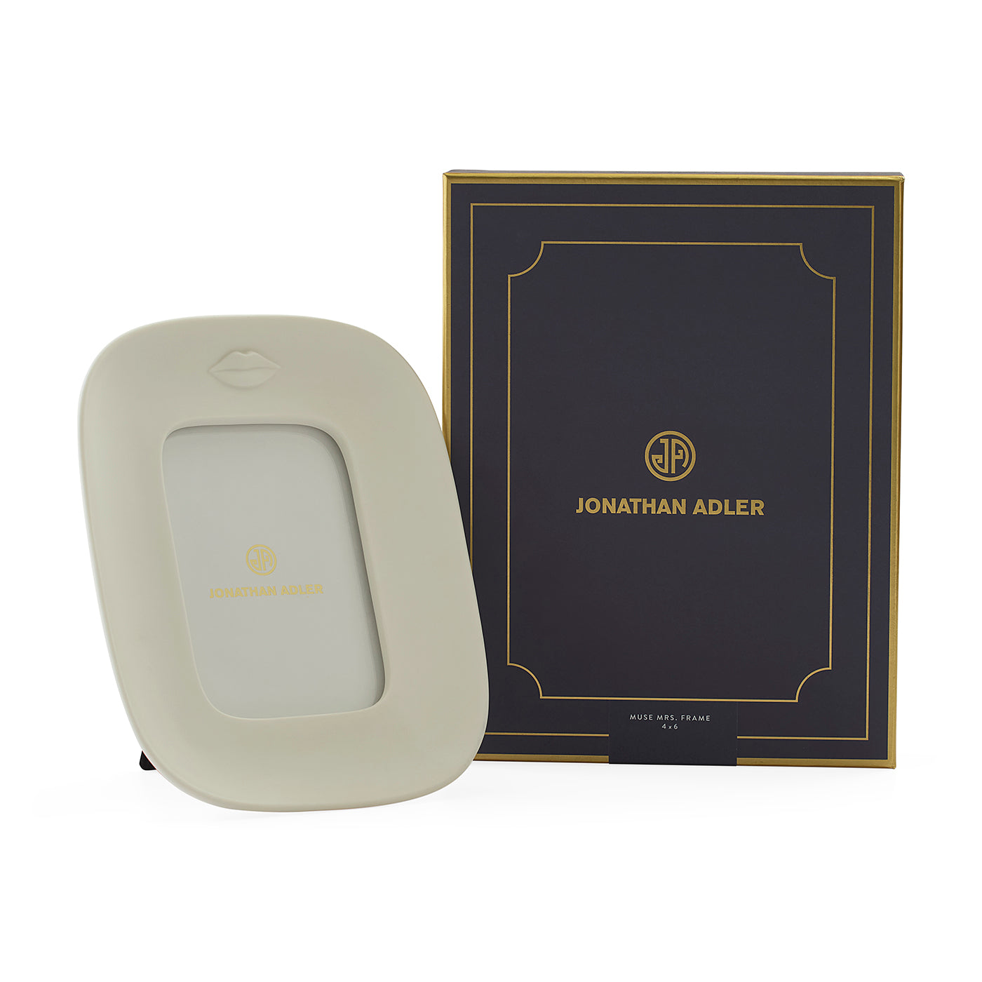 A cream-colored Jonathan Adler picture frame with a gold logo, shown next to its black and gold branded presentation box on a white background.