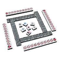 A set of Mahjong tiles arranged on a plain white background, with a rectangular outer wall and several inner tiles fanned out in the center. The tiles are predominantly white with black geometric patterns and red circular markings, plus a few smaller tiles showing blue, pink, and gray designs.