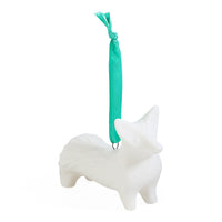 A white ceramic dog-shaped Christmas ornament with a teal green hanging ribbon, shown against a plain white background.