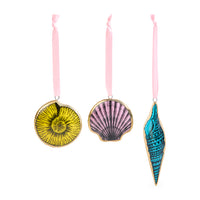 Three hanging seashell-shaped ornaments in yellow, pink, and blue with gold trim and pink ribbons, displayed on a white background.