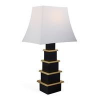 Table lamp with black and gold base and white shade on a white background