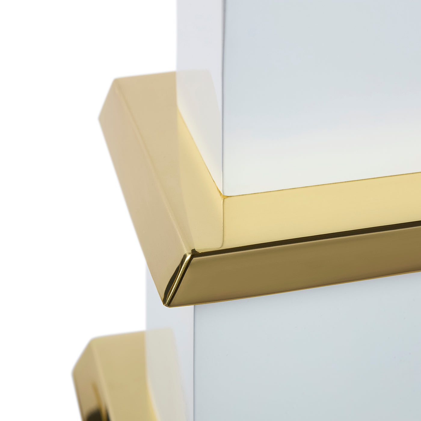Close-up of a white surface with gold trim on a white background
