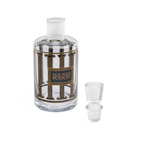A clear glass decanter bottle with a matching glass stopper, featuring a decorative label with classical columns and the text 'PICK YOUR POISON'.