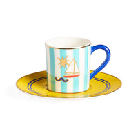 Cup and saucer with sailboat design on a white background