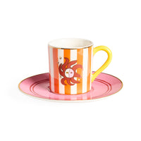 Ceramic cup with saucer featuring a sun design on a white background