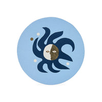 Decorative coaster with sun and moon design on a light blue background