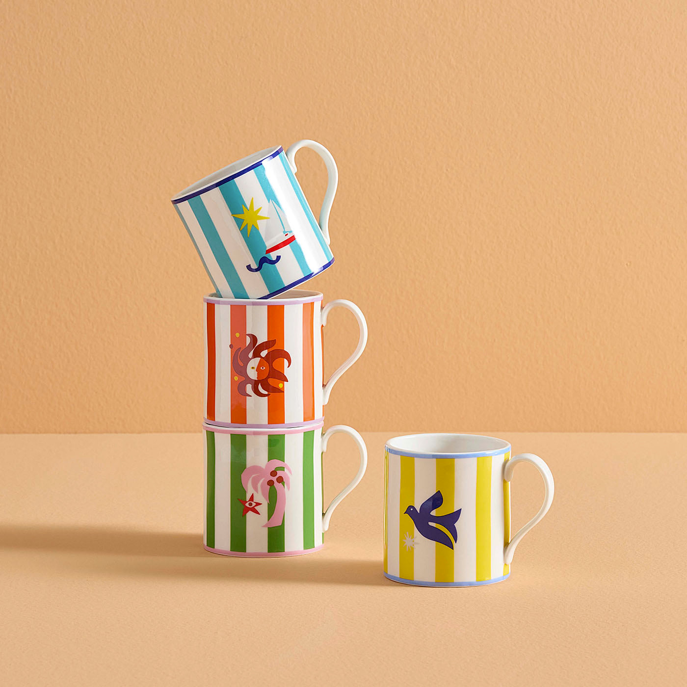 Stack of three mugs with colorful designs on a beige background