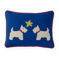 A square blue throw pillow with a red border, featuring two white Scottie dogs facing each other with a yellow star embroidered between them.