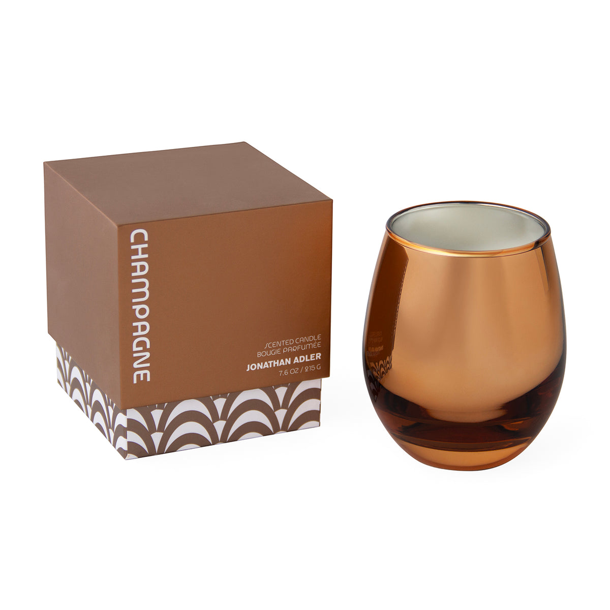 Jonathan Adler Champagne scented candle in an amber-tinted stemless glass vessel, shown next to its brown packaging box with 'CHAMPGNE' printed vertically on the side.