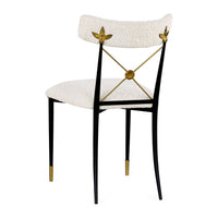 Decorative chair with white cushioned seat and backrest, gold accents, and black legs on a white background.