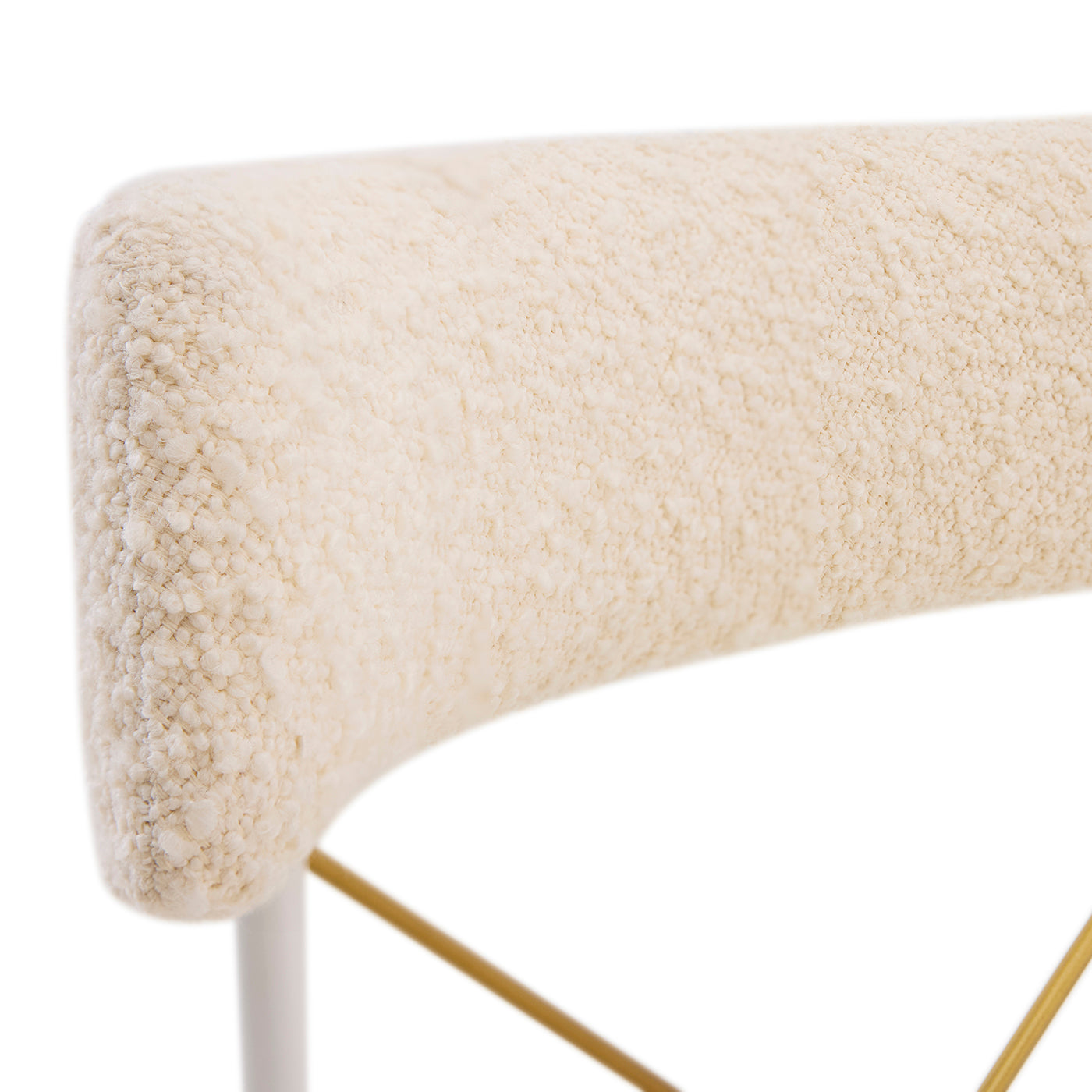 Close-up of a textured beige surface with a white base and gold legs on a white background