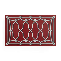 A rectangular decorative wall plaque featuring a white ornamental knotwork pattern on a deep red background, shown against a plain white studio backdrop.