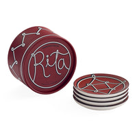 A set of four red coasters with white line-art designs, including one coaster standing upright to show the printed design and the others stacked to show the side profile.