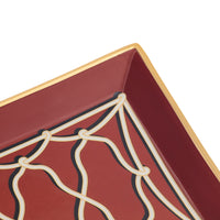 Close-up of a square decorative tray corner with a deep burgundy interior, cream web-like line pattern, and a gold rim on a white background.