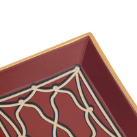 Close-up of a square decorative tray corner with a deep burgundy interior, cream geometric lattice pattern, and a gold-toned rim on a white background.