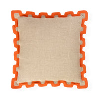 A square throw pillow with a textured beige linen-like center and a bright orange interlocking puzzle-style border, shown on a plain white background.