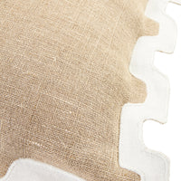 Close-up of a beige woven textile with a white scalloped border on a white background.