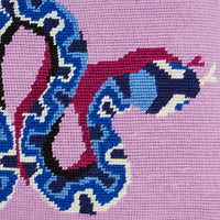 Close-up of a cross-stitched design on fabric with blue, pink, and black colors.
