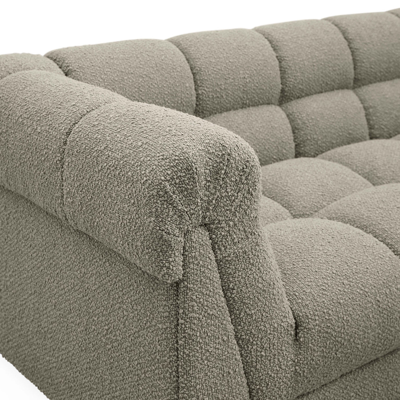 Close-up of a textured gray sofa with tufted backrests.