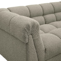 Close-up of a textured gray sofa with tufted backrests.
