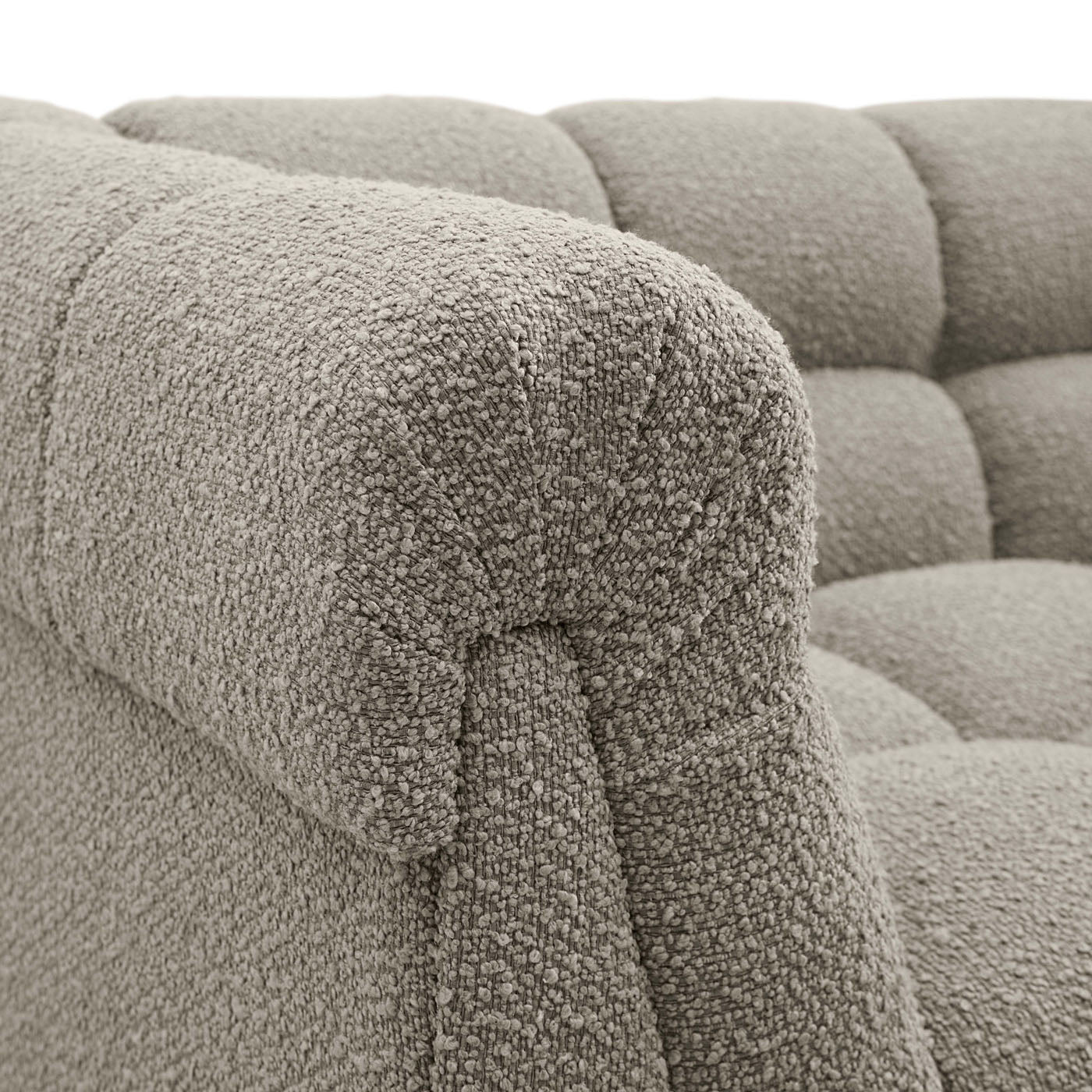 Close-up of a textured gray sofa with tufted backrests.