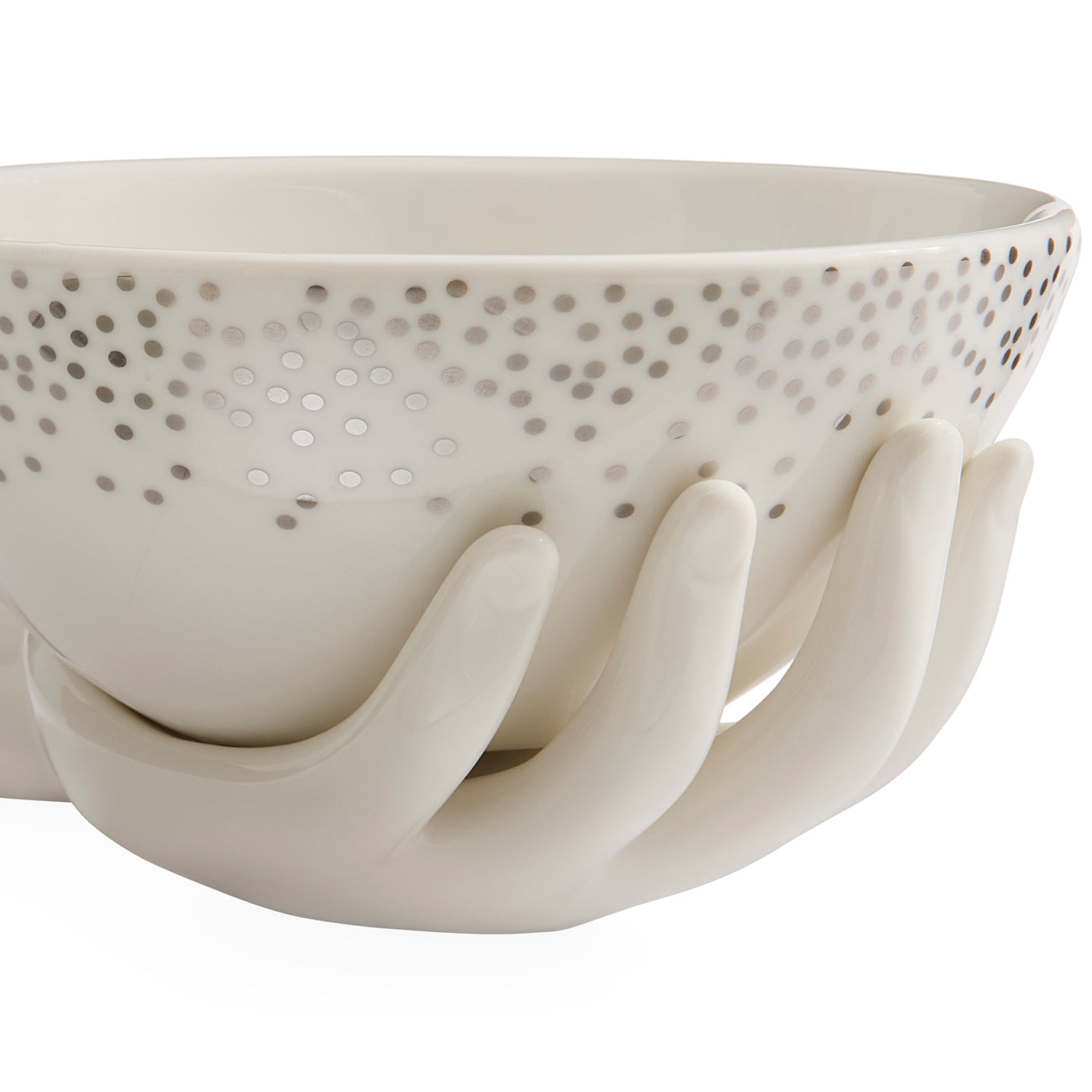 A white ceramic bowl with a perforated pattern of small dots on the exterior, supported by sculptural hand-shaped bases, shown against a plain white background.