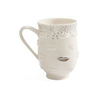 A white ceramic mug shaped like a stylized face with a dotted pattern around the upper rim and a metallic silver lip detail, shown on a plain white background.