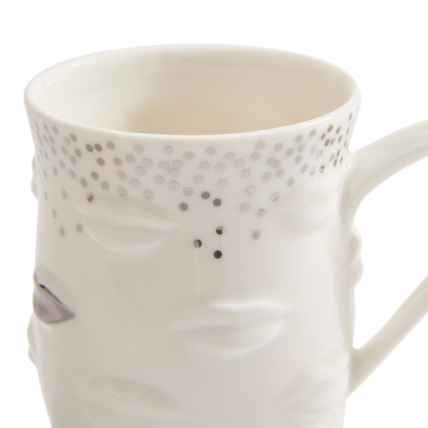 A white ceramic mug featuring a sculpted face design with closed eyes and a dotted pattern around the upper rim, shown on a clean white background.