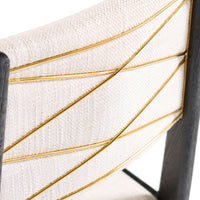 Close-up of a chair with gold wire detailing on a white background