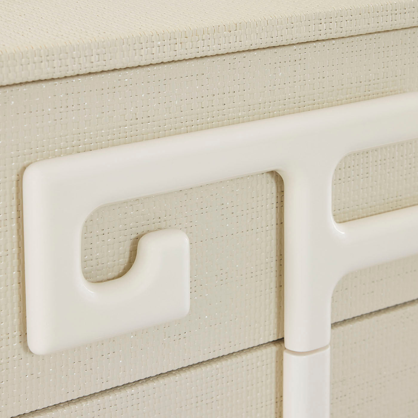 Close-up of a beige textured surface with a white handle and leg.